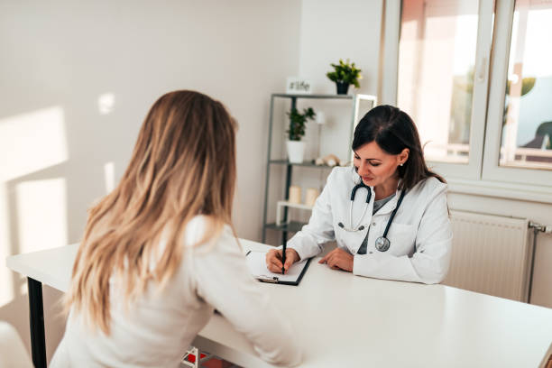 female doctor writing prescription to her young patient. - medical visit imagens e fotografias de stock