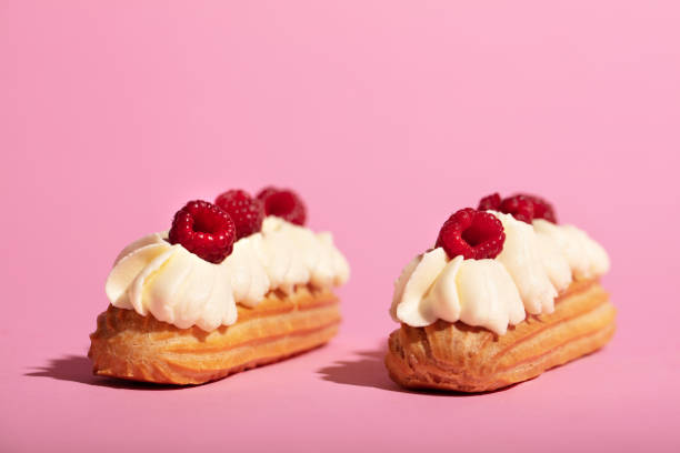 istock Two colorful eclairs laying on pink background. 1060939466