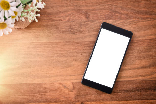 istock Black portable phone on wooden isolated table 1060939830