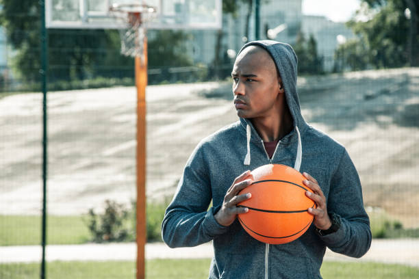 istock Serious young man holding a basketball ball 1060956526