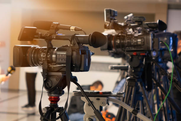 istock News conference. Filming an event with a video camera. 1060956702