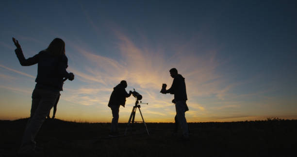 istock Friends on shore in twilight looking through telescope 1060959248