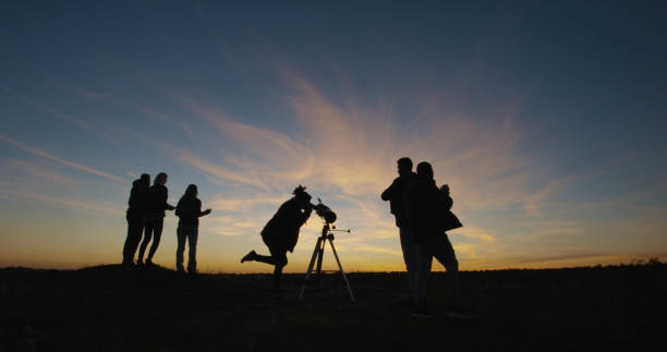 istock Friends on shore in twilight looking through telescope 1060959252