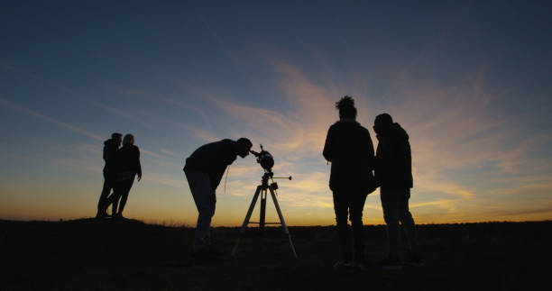 istock Friends on shore in twilight looking through telescope 1060959256