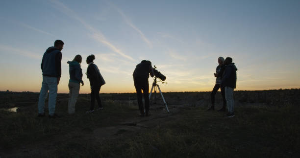 istock Friends on shore in twilight looking through telescope 1060959258