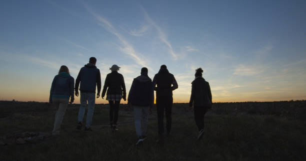 istock Friends walking together into the setting sun 1060959334