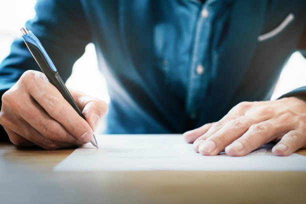 close up businessman signing contract making a deal - pen business person men standing imagens e fotografias de stock