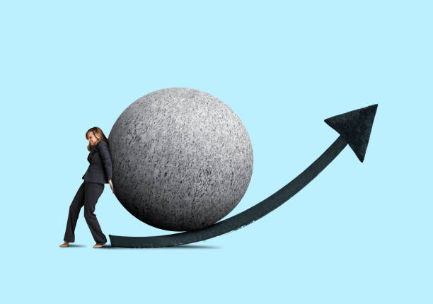istock Businesswoman Attempting To Push Large Sphere Uphill 1060965078