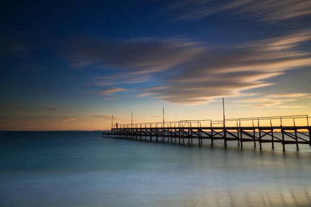 istock Pier on the beach at sunset 1060966072