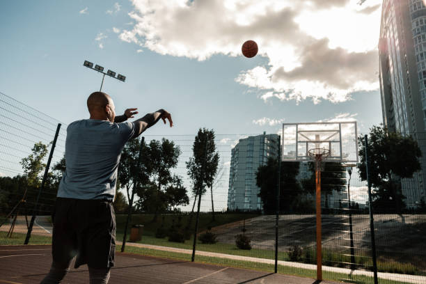 palla da basket arancione nell'aria - streetball basketball sport men foto e immagini stock