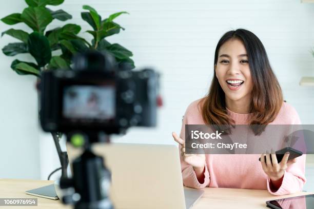 Foto de Blogger Jovem Mulher Asiática Atraente Ou Vlogger Olhando Para A Câmera E Falando No Vídeo Fotografar Com Tecnologia Mídias Sociais Influenciador Pessoas Ou Conteúdo Fabricante Conceito Em Relaxar Estilo Casual Em Casa e mais fotos de stock de Influencer