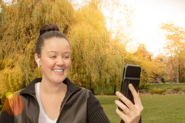 istock Woman on a smart phone outside listning on her ear buds 1060977570