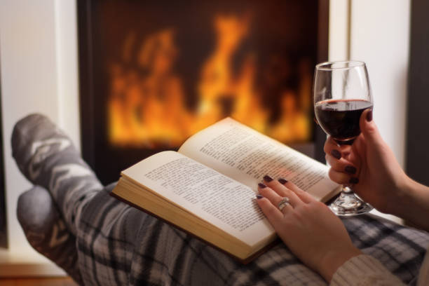 책을 읽고 하 고 벽난로 앞 레드 와인을 마시는 여자 - blanket fireplace winter women 뉴스 사진 이미지