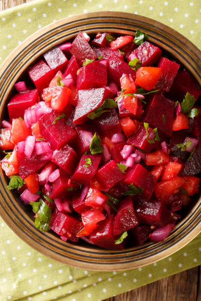 istock African food: Moroccan beetroot salad with onions, tomatoes and herbs close-up. Vertical top view from above 1060985472