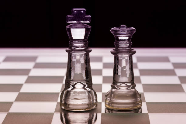 istock King and queen glass chess pieces facing each other in black and white 1060987638