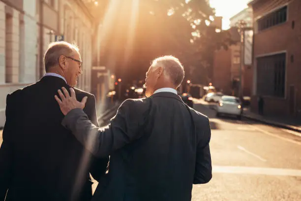 Photo of Two senior business people walking outdoors