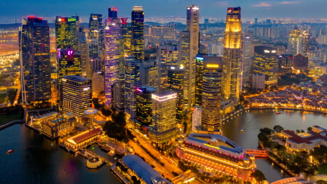 Aerial view dronelapse or hyperlapse of financial central business district building of Singapore city at night with Fullerton Road and Promontory