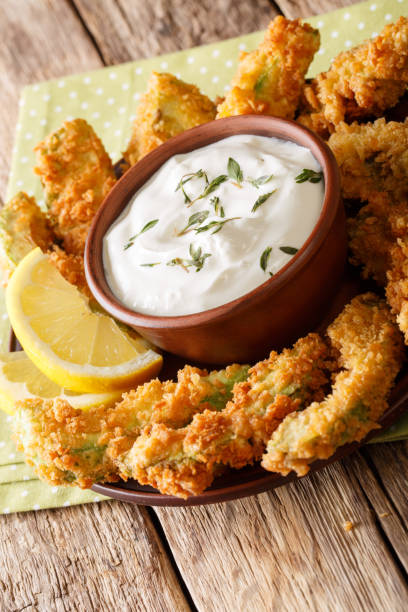 istock Fried avocado in breaded panko with spicy sauce and lemon close-up. vertical 1060989020