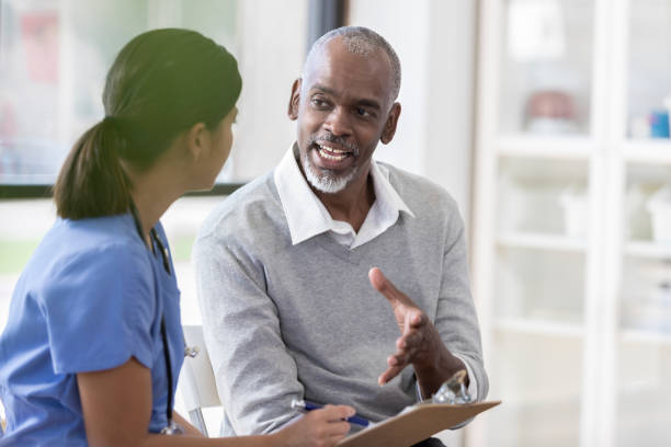 istock Senior man talking with young female nurse 1060998658