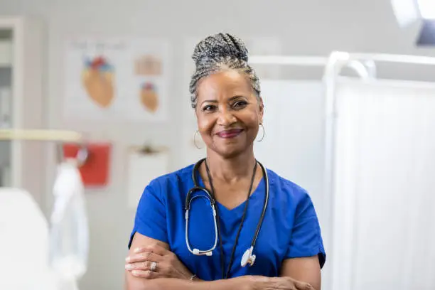 Photo of Portrait of confident senior female doctor in scrubs