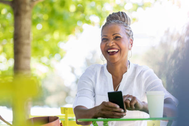 istock Beautiful senior woman smiles while scrolling on mobile phone 1061005716