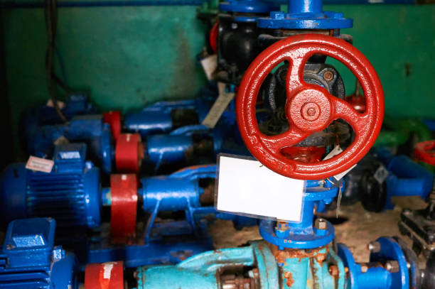 istock Old black valve with red handles on the blue-painted cold water pipeline. 1061007054