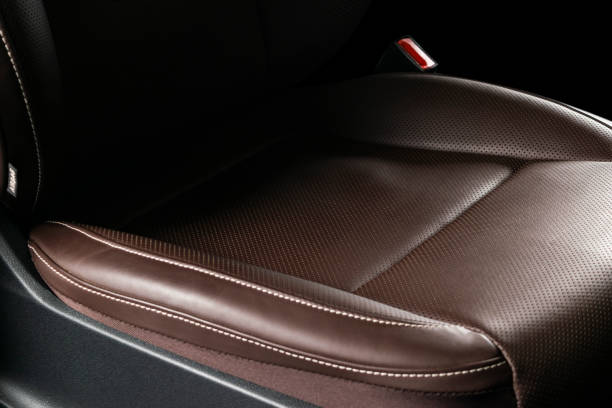 istock Car brown leather interior. Part of leather car seat details with white stitching. Interior of a car. Comfortable perforated leather seats. Brown perforated leather. Car detailing 1061016830