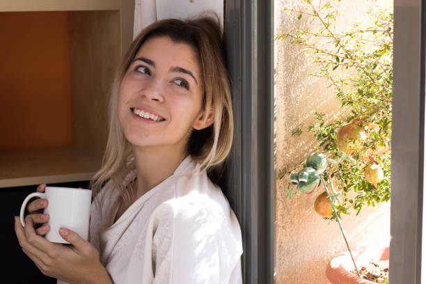 istock Woman drinking coffee near a window 1061016976