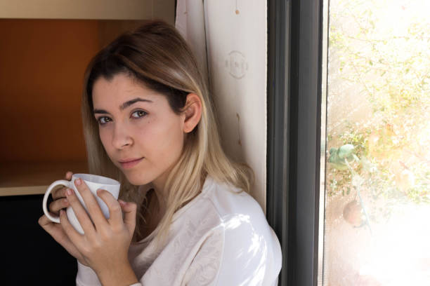 istock Woman drinking coffee near a window 1061016998