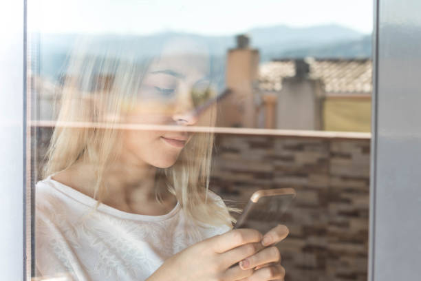 istock Girl with a smartphone next to a window 1061017086