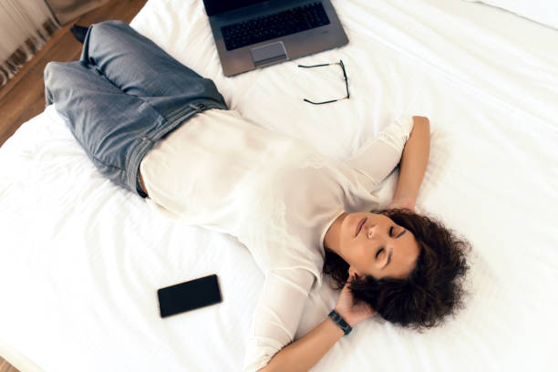 istock Businesswoman Resting on Hotel Bed 1061021478