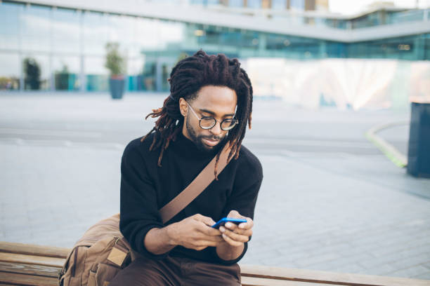 istock Handsome man sitting on a bench with a mobile phone 1061022502