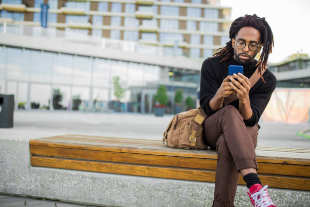 istock Handsome man sitting on a bench with a mobile phone 1061024882