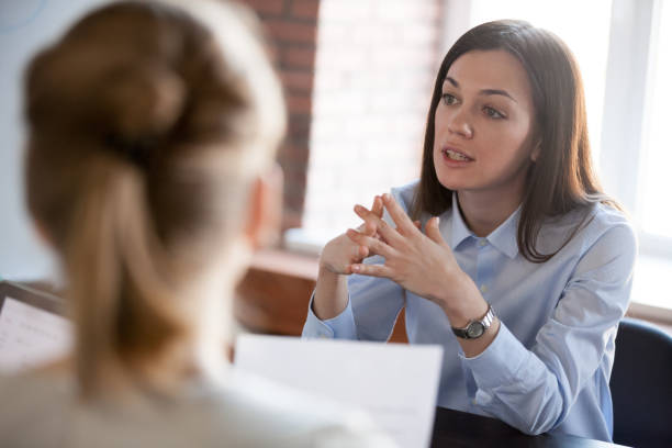 confident focused businesswoman speaking to people at business negotiations - human resources interview talking people imagens e fotografias de stock