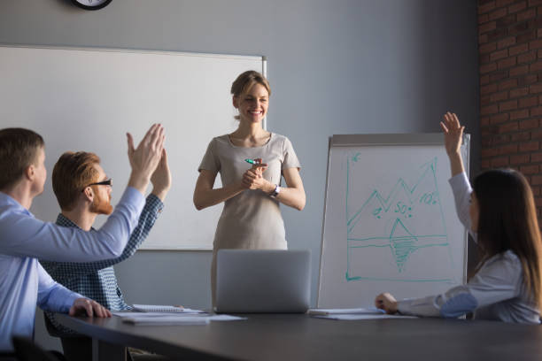 istock Female coach feeling satisfied looking at business audience raising hands 1061027850