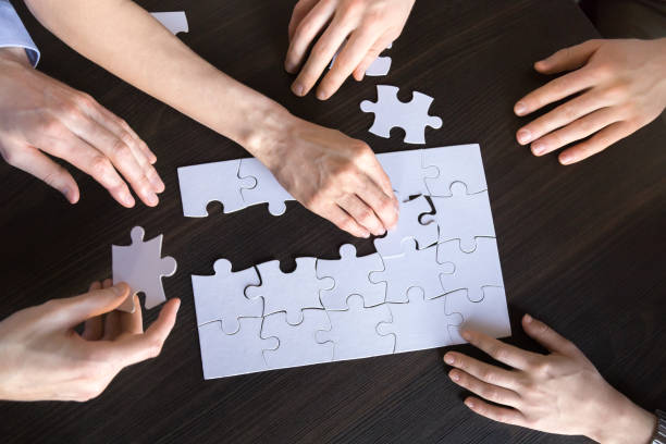 istock Corporate team people connecting puzzle working together, top closeup view 1061028000