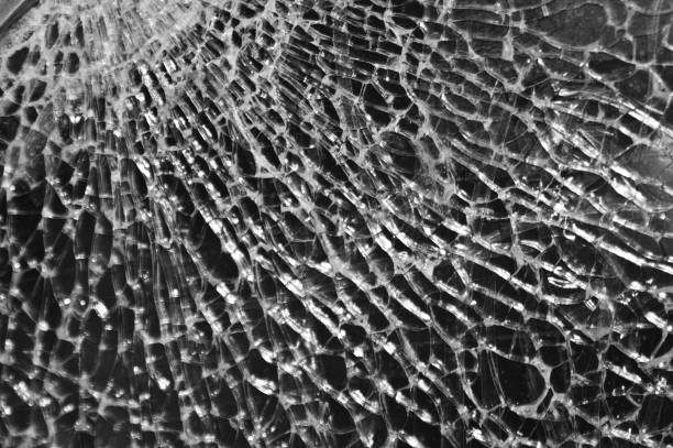 istock Black-and-white Texture of broken glass on dark background. Closeup 1061028116