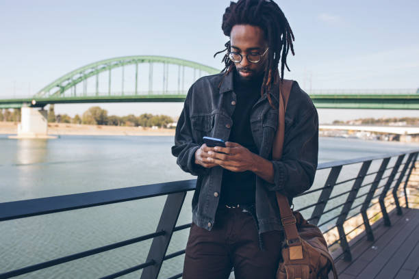 istock Smiling man using smart phone outdoors 1061030348