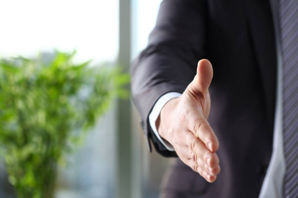 istock Man in suit and tie give hand as hello in office 1061035090