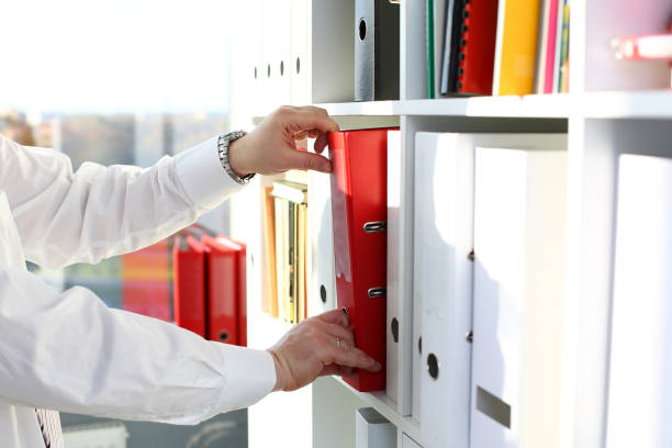 bras masculins choisir dossier rouge d’étagère de bureau - ring binder file document organization photos et images de collection