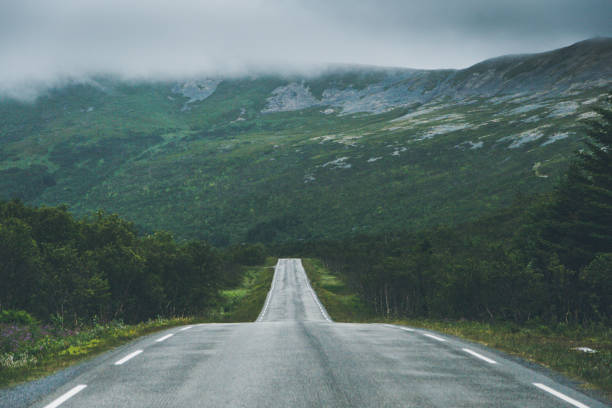 Straight road against mountainside. Straight road against mountainside in fog. middle of the road stock pictures, royalty-free photos & images