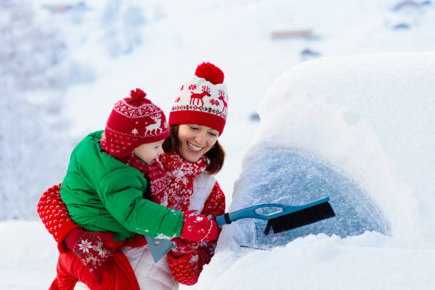 istock Mother and child brushing off car in winter. 1061037064