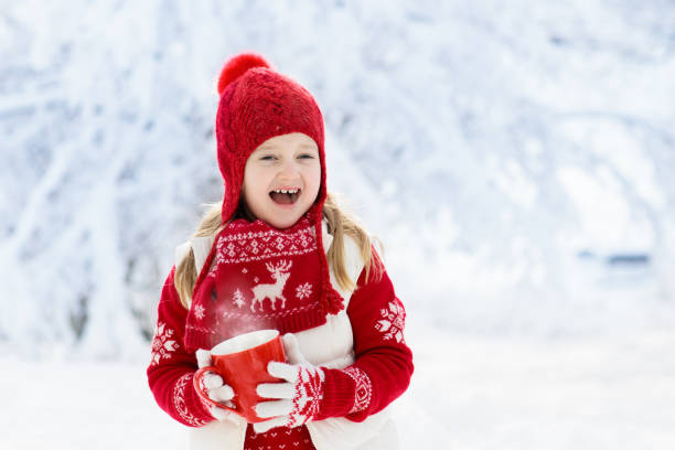 istock Child drinking chocolate on Christmas in snow 1061037720