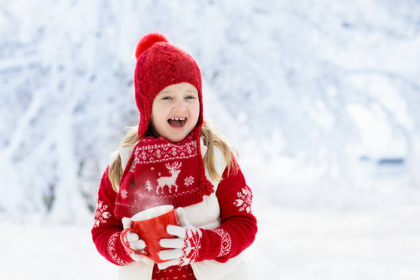 criança beber chocolate no natal na neve - 16727 - fotografias e filmes do acervo