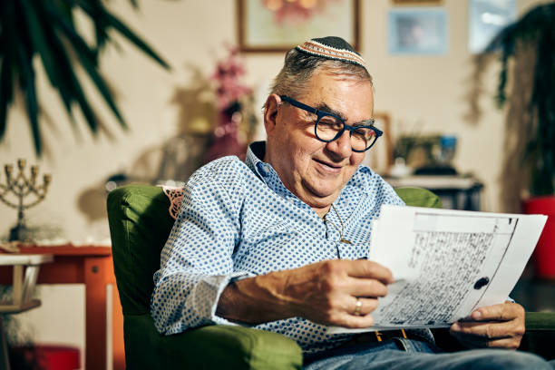 Jewish senior with glasses in the armchair reading a torah book Jewish senior with glasses sitting in the armchair reading a torah book yarmulke photos stock pictures, royalty-free photos & images