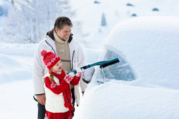 istock Father and child brushing off car in winter. 1061040554