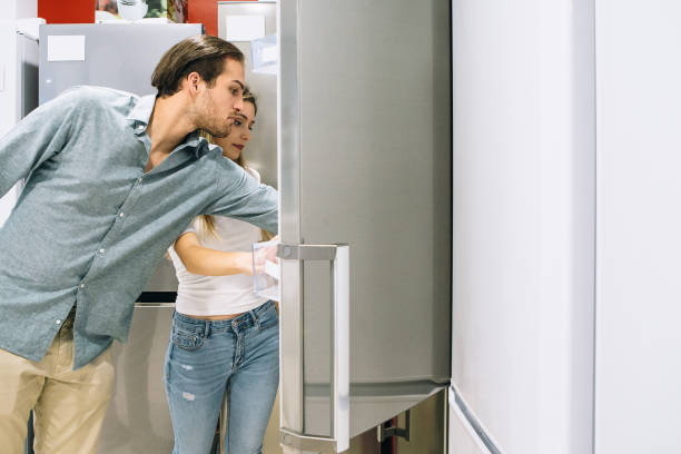 istock Young man and woman choosing a fridge 1061043350
