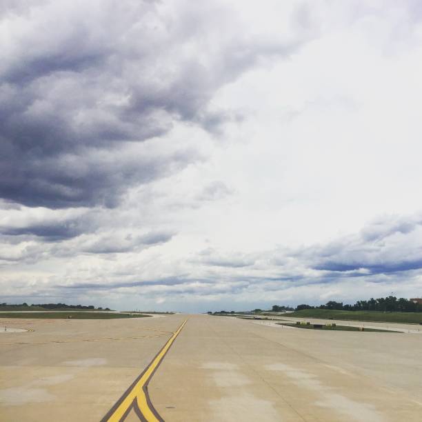 istock Open airport runway with clouds in sky 1061046062
