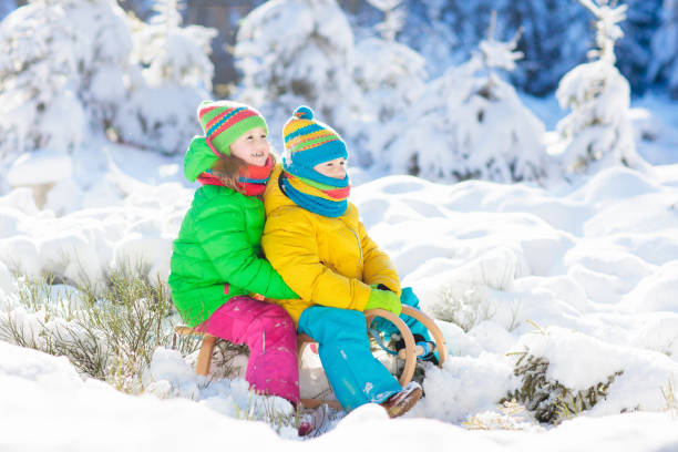 los niños jugar en la nieve. paseo del trineo de invierno para niños - 16725 fotografías e imágenes de stock