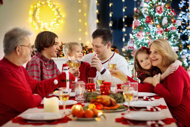 istock Family with kids having Christmas dinner at tree 1061051406